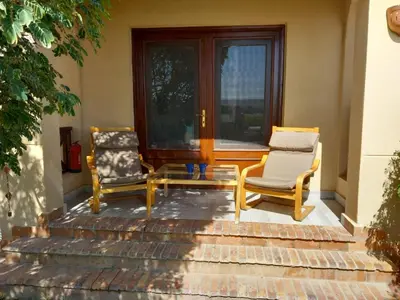 two chairs and a table on a porch at Peaceful & bright lagoon escape - Shared infinity Pool - 1BR - Sabina, El Gouna in Hurghada