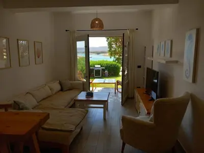 a living room with a couch and a table and a television at Peaceful & bright lagoon escape - Shared infinity Pool - 1BR - Sabina, El Gouna in Hurghada