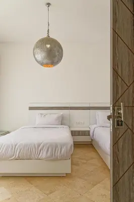 a bedroom with two beds and a pendant light at VESTA - El Gouna Residence in Hurghada