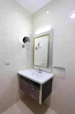 a bathroom with a sink and a mirror at Magawish Bliss , Elegant Hurghada Apartment in Hurghada