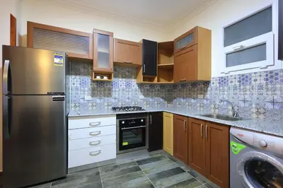 a kitchen with a stainless steel refrigerator and a dishwasher at Magawish Bliss , Elegant Hurghada Apartment in Hurghada