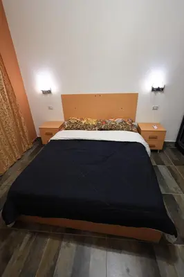 a large bed in a room with two night stands at Magawish Bliss , Elegant Hurghada Apartment in Hurghada