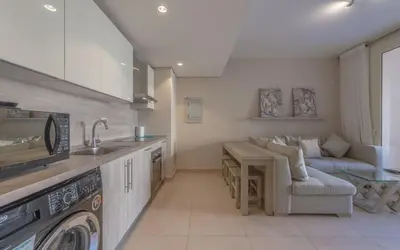 a kitchen with a sink and a living room at New 1BR Apartment in Mangroovy El Gouna Pool, Beach, The Red Sea in Hurghada