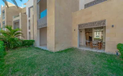 a building with a patio with a table and chairs at New 1BR Apartment in Mangroovy El Gouna Pool, Beach, The Red Sea in Hurghada