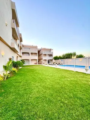 a large lawn in front of a building with a swimming pool at Royal Nile Villa - Luxury Nile Sky Penthouse 2 in Al Aqālitah
