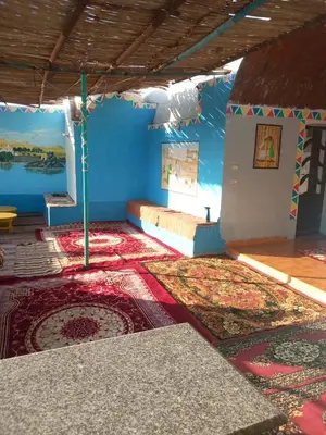 a room with blue walls and floors with rugs at Nubian house in Jazīrat Salūjah