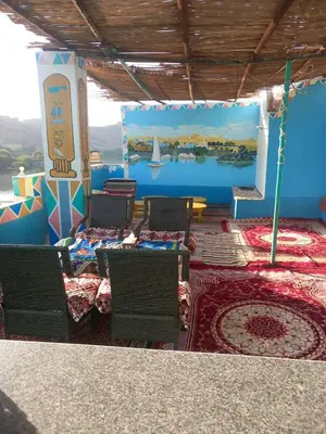 a room with chairs and a wall with a mural at Nubian house in Jazīrat Salūjah