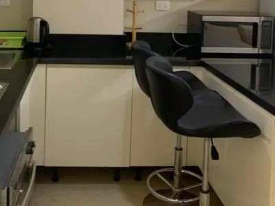 a black chair sitting in a kitchen next to a microwave at One-Bedroom Chalet at Turtles Beach Resort , Pool & Side Sea View C22 in Hurghada