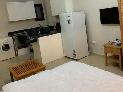 a room with a kitchen with a refrigerator and a bed at One-Bedroom Chalet at Turtles Beach Resort , Pool & Side Sea View C22 in Hurghada