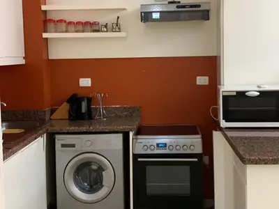 a kitchen with a washing machine and a microwave at One-Bedroom Chalet with Side Sea View , Turtles Beach C23 in Hurghada