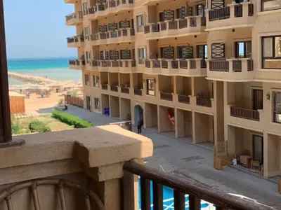 a view from a balcony of a building with the beach at One-Bedroom Chalet with Side Sea View , Turtles Beach C23 in Hurghada