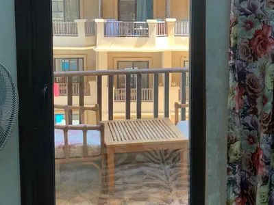 a view of a balcony with a wooden bench at One-Bedroom Chalet with Side Sea View , Turtles Beach C23 in Hurghada