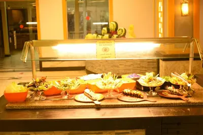 a buffet line with different types of food at Mirage Bay Resort Aquapark SAM Suite in Hurghada