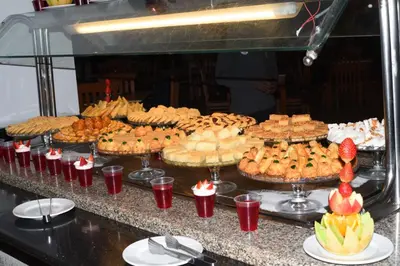 a buffet with many different types of cakes and pies at Mirage Bay Resort Aquapark Ghada Suite in Hurghada