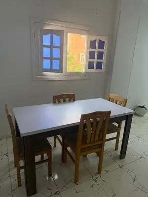 a dining room table with chairs and a window at Simplestays Hurghada in Hurghada