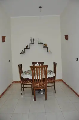 a dining room with a table and chairs and stairs at White Villa in Luxor
