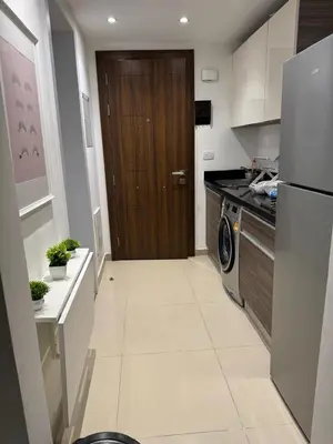 a kitchen with a refrigerator and a washer at Chic G Cribs Studio in El Gouna