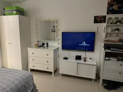 a bedroom with a bed and a flat screen tv at Chic G Cribs Studio in El Gouna