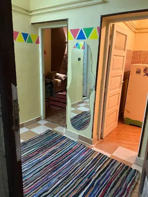 a room with a door open to a room with a refrigerator at SolNest Guest House in Jazīrat Aswān