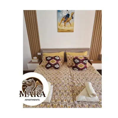 a bedroom with a bed with a comforter and pillows at MARA Apartments Florenza Khamsin in Hurghada