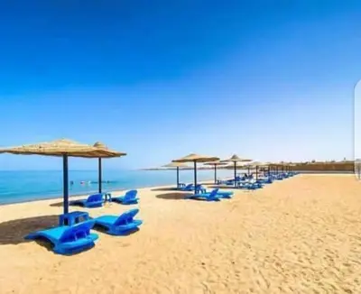 a group of blue chairs and umbrellas on a beach at Cecilia Resort Hurghada in Hurghada