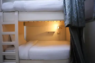 two bunk beds in a room with a ladder at Pajama Hostel Nile View in Aswan