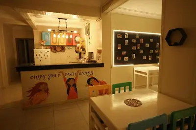 a kitchen with a table and a counter with a sign at Pajama Hostel Nile View in Aswan
