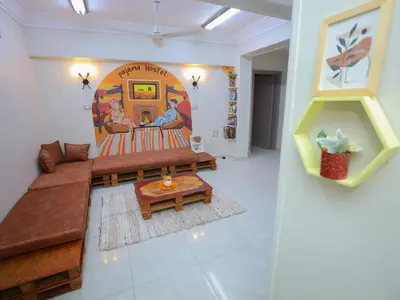 a living room with a couch and a painting on the wall at Pajama Hostel Nile View in Aswan