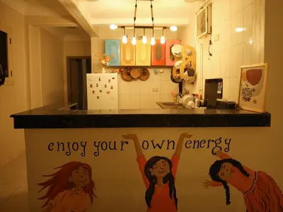 a kitchen with a counter with a sign saying enjoy your own energy at Pajama Hostel Nile View in Aswan