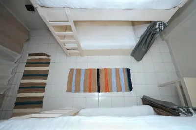 a bedroom with a bed and a ladder and a rug at Pajama Hostel Nile View in Aswan