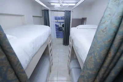 a room with two beds and a window at Pajama Hostel Nile View in Aswan