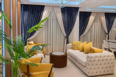 a living room with a white couch and blue curtains at Hurghada Sky Villa in Hurghada