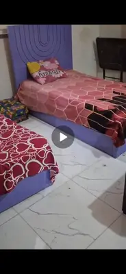 a bedroom with two beds and a purple headboard at Aswan in Naj‘ al Maḩaţţah
