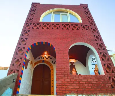 a red brick tower with a window and a door at Casa Nile View rooms - Nubian House -by kerma hospitality in Aswan