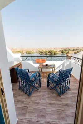 a balcony with blue chairs and a table on a ship at Casa Nile View rooms - Nubian House -by kerma hospitality in Aswan
