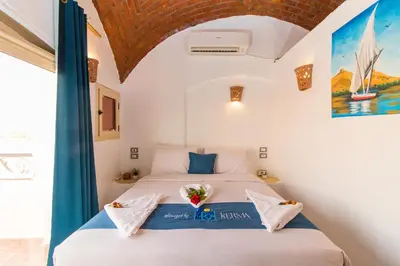 a bedroom with a bed with flowers on it at Casa Nile View rooms - Nubian House -by kerma hospitality in Aswan