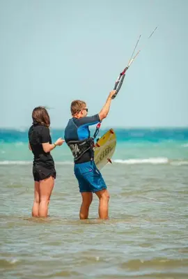 two people standing in the ocean holding onto a kite at 2bedroom in selena bay resort in Hurghada