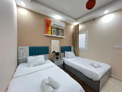 two beds in a small room with white sheets at 2bedroom in selena bay resort in Hurghada