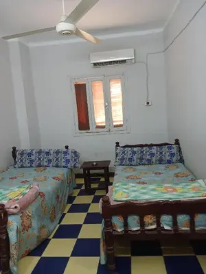 a bedroom with two beds and a ceiling fan at New Alsalam Hotel in Luxor