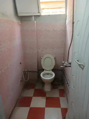 a small bathroom with a toilet and a checkered floor at New Alsalam Hotel in Luxor