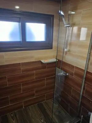 a bathroom with a glass shower with a window at King Arthur luxury Dahabyaa in Luxor