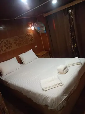 a bedroom with a bed with two towels on it at King Arthur luxury Dahabyaa in Luxor