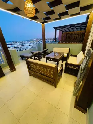 a balcony with couches and a table and a view at New Marina Luxury Suite in Hurghada