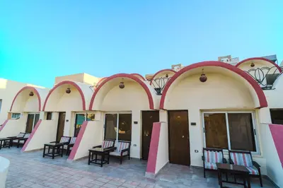 a row of arches on a building with tables and chairs at Geisum beach hotel in Hurghada