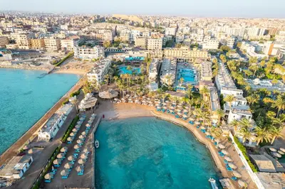 an aerial view of a beach with umbrellas and the ocean at Geisum beach hotel in Hurghada