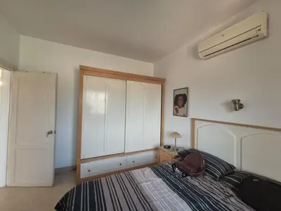 a bedroom with a bed and a white cabinet at K31 Peaceful 2 Bedrooms Nile Resort Flat in Luxor in Luxor