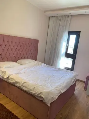 a bedroom with a large bed with a headboard and a window at for the best all-rounder sea view Hurghada Apartment&DownTown AlDau in Banī Ghālib