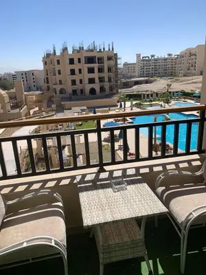a balcony with a table and a swimming pool at for the best all-rounder sea view Hurghada Apartment&DownTown AlDau in Banī Ghālib