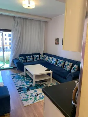 a living room with a blue couch and a table at for the best all-rounder sea view Hurghada Apartment&DownTown AlDau in Banī Ghālib