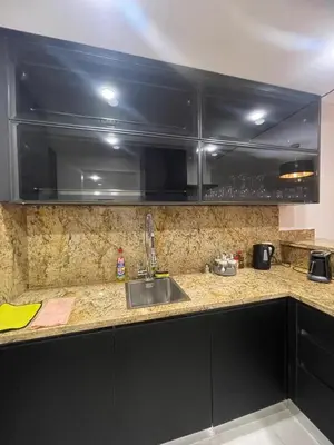 a kitchen with black cabinets and a sink at Special Apartment For Rent 103 in Hurghada